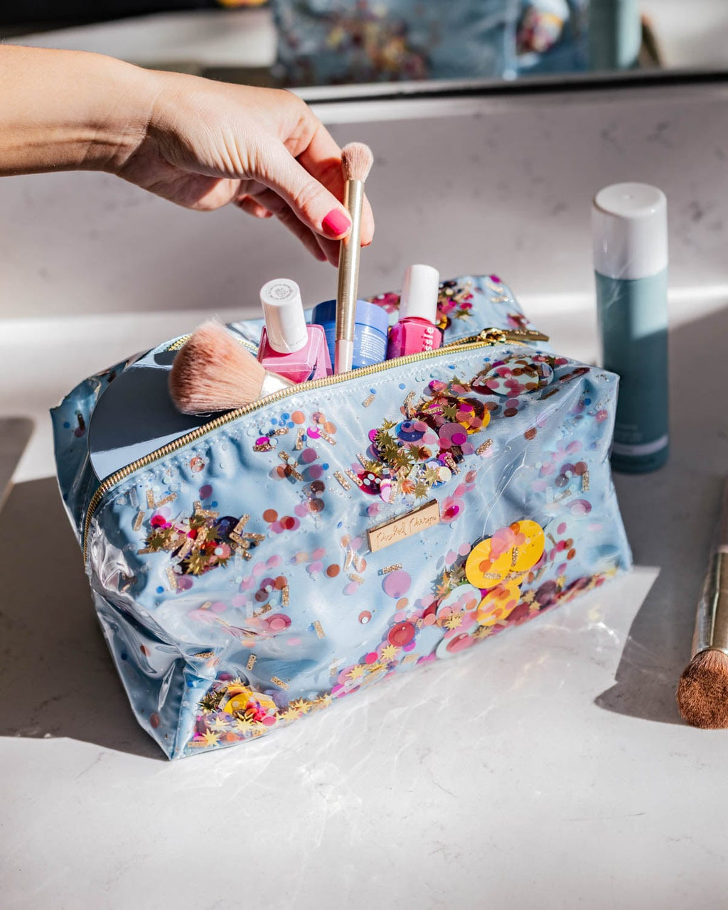 Clear vinyl confetti cosmetic bag with three compartments